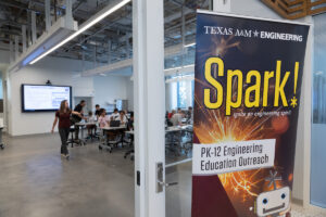 A Texas A&M Engineering "Spark!" banner marks a PK-12 engineering education outreach event in a modern classroom with students and educators engaged in learning activities.